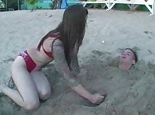 mistress plays with slave in a beach