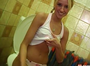 A blonde with pigtails sneaks into the bathroom with her toy