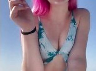 Beautiful girl smoking cigarettes on the beach